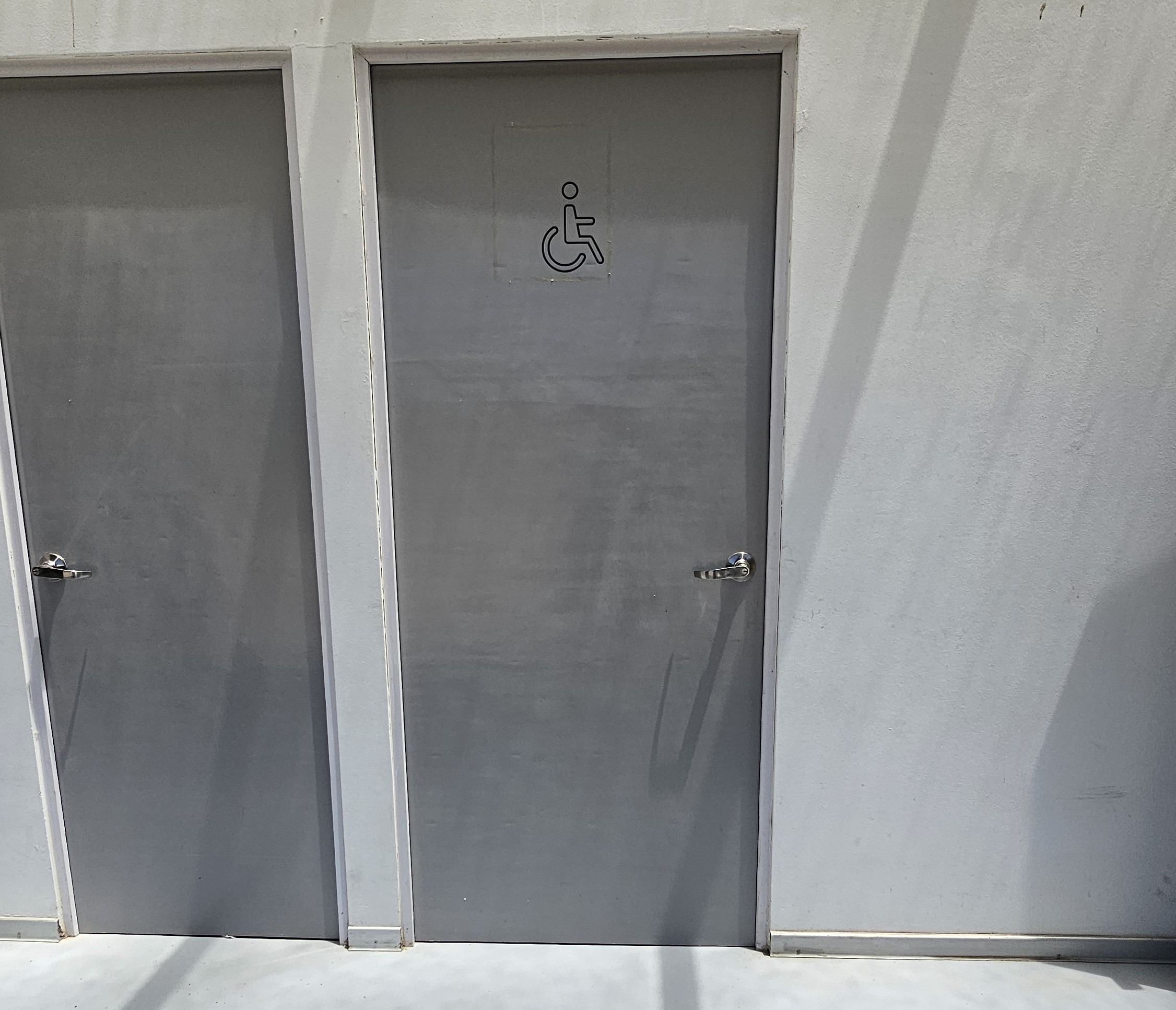 fotografía de la puerta del baño accesible, cuenta con el símbolo de silla de ruedas